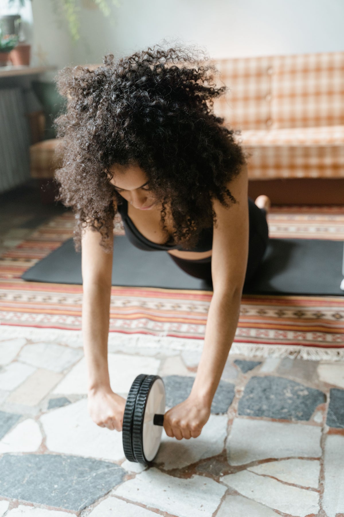 Woman using an ab wheel on a mat